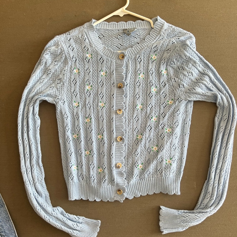 Cardigan sweater light blue with white daisies. Size: Large